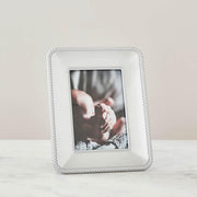 Nambé Braid Photo Frame in a display setting; other items shown are sold separately.